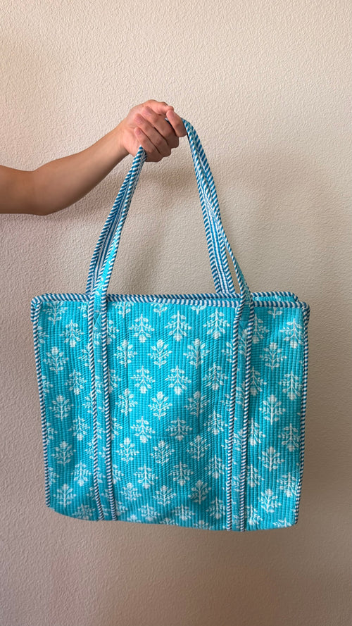 Hand-block printed quilted cotton tote bag. Featuring crisp white motifs on a striking turquoise base.