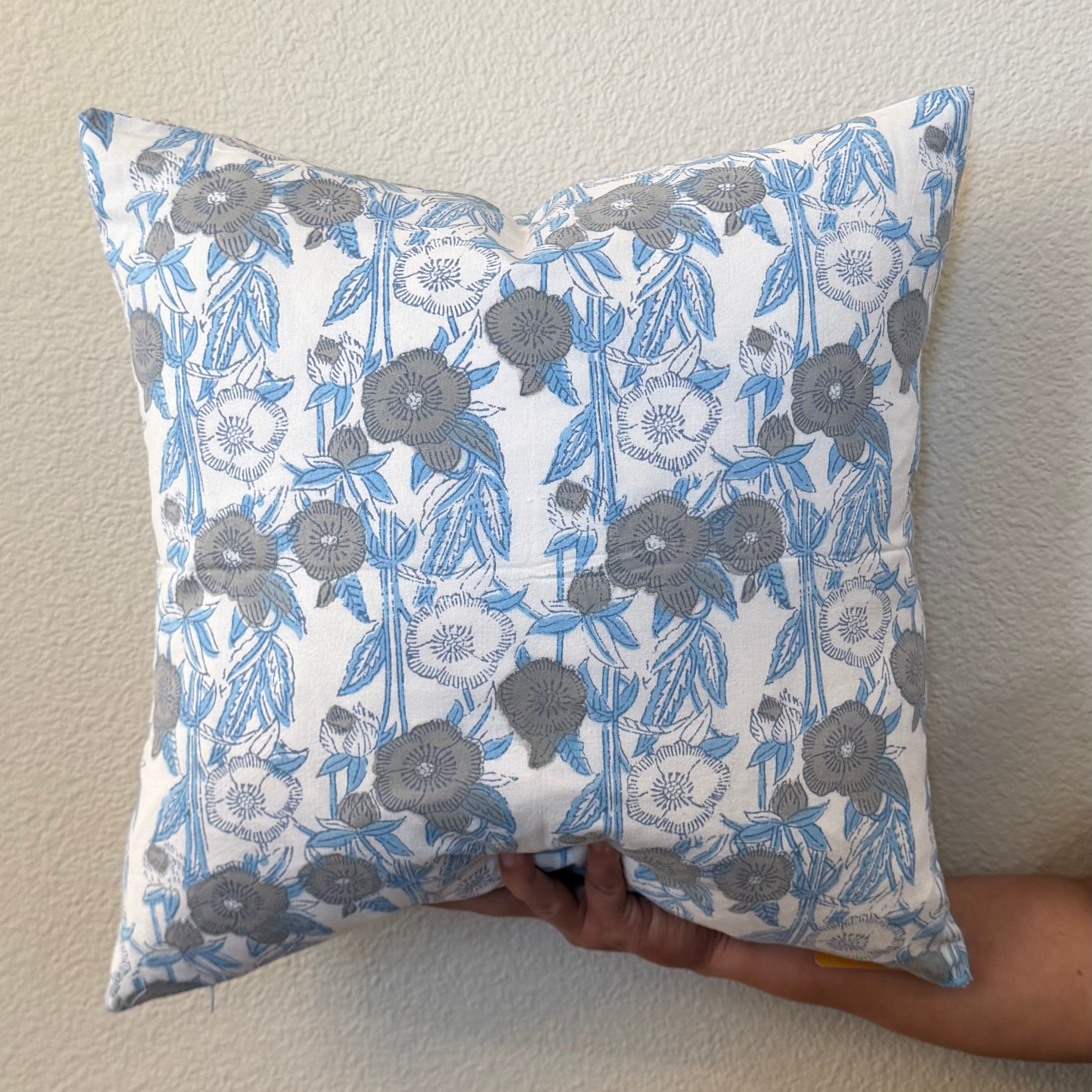 Hand Block printed throw pillow with floral motifs in muted Blues and Grays.
