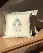 Abstract quilted hand-block printed throw pillow on a sunlit bench. 