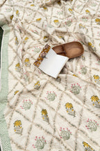 Floral-patterned quilt with a wooden spoon and white container on top