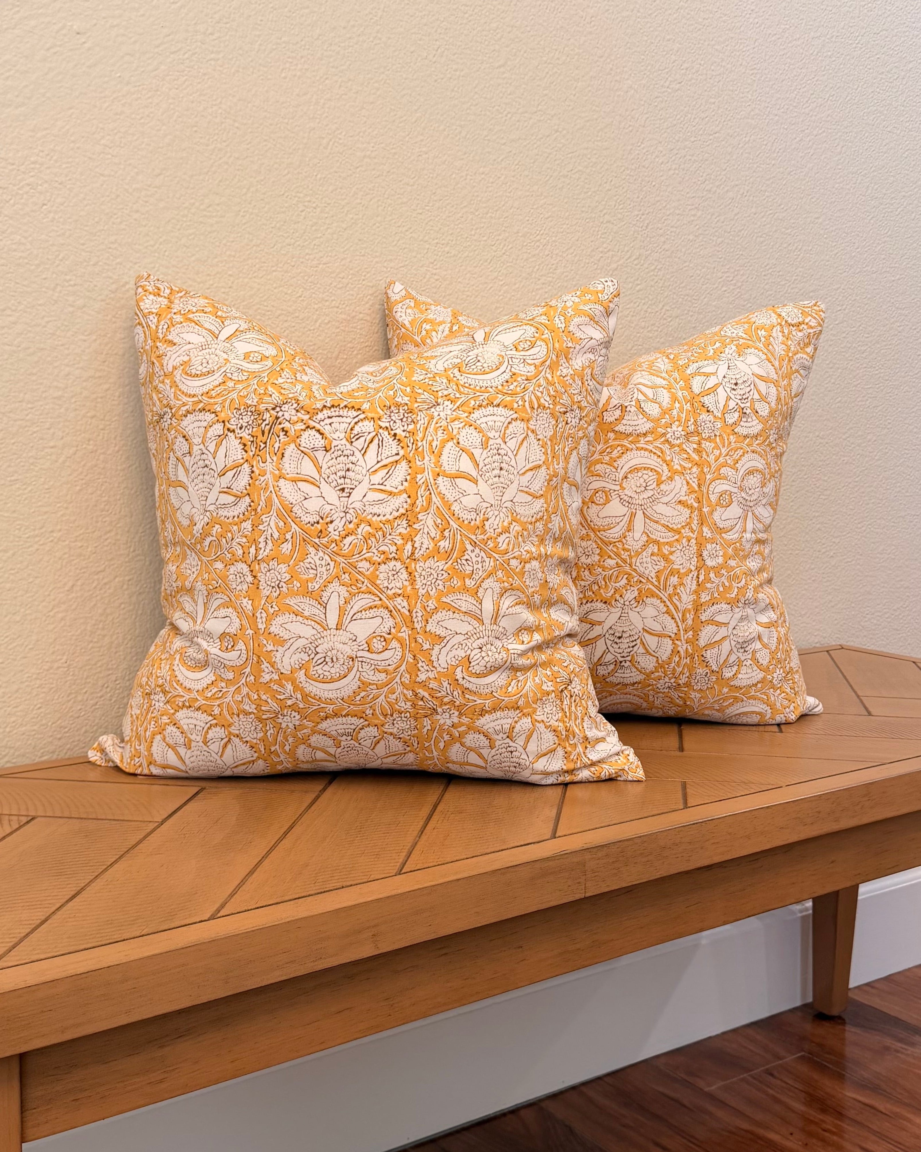 Hand Block printed throw pillow with floral vine motifs in muted ochre and brown.