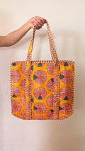 Hand-block printed quilted cotton tote bag. Bold bright orange with circular geometric patterns.