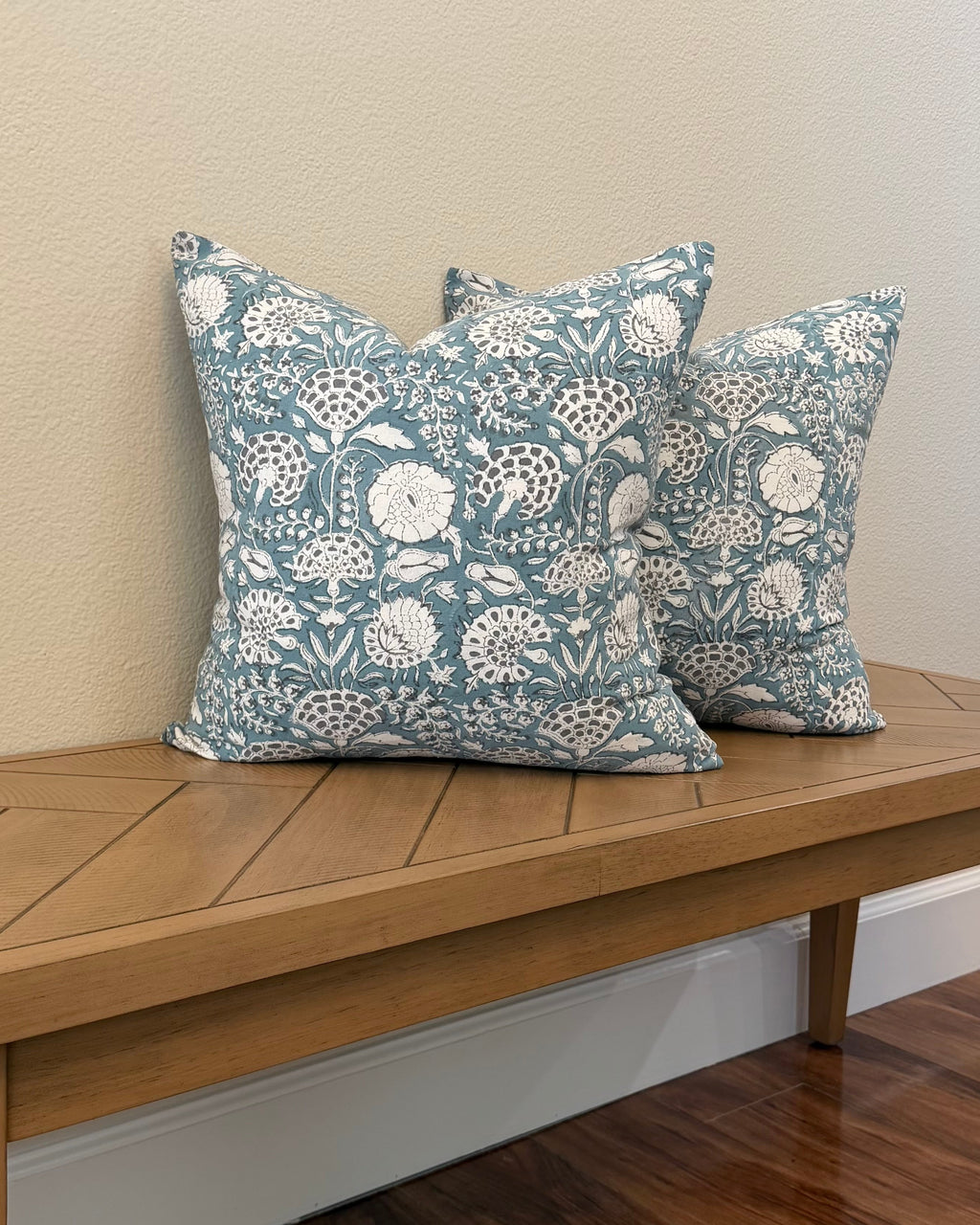 Hand Block printed throw pillow with floral vine motifs in muted bluish gray and white.