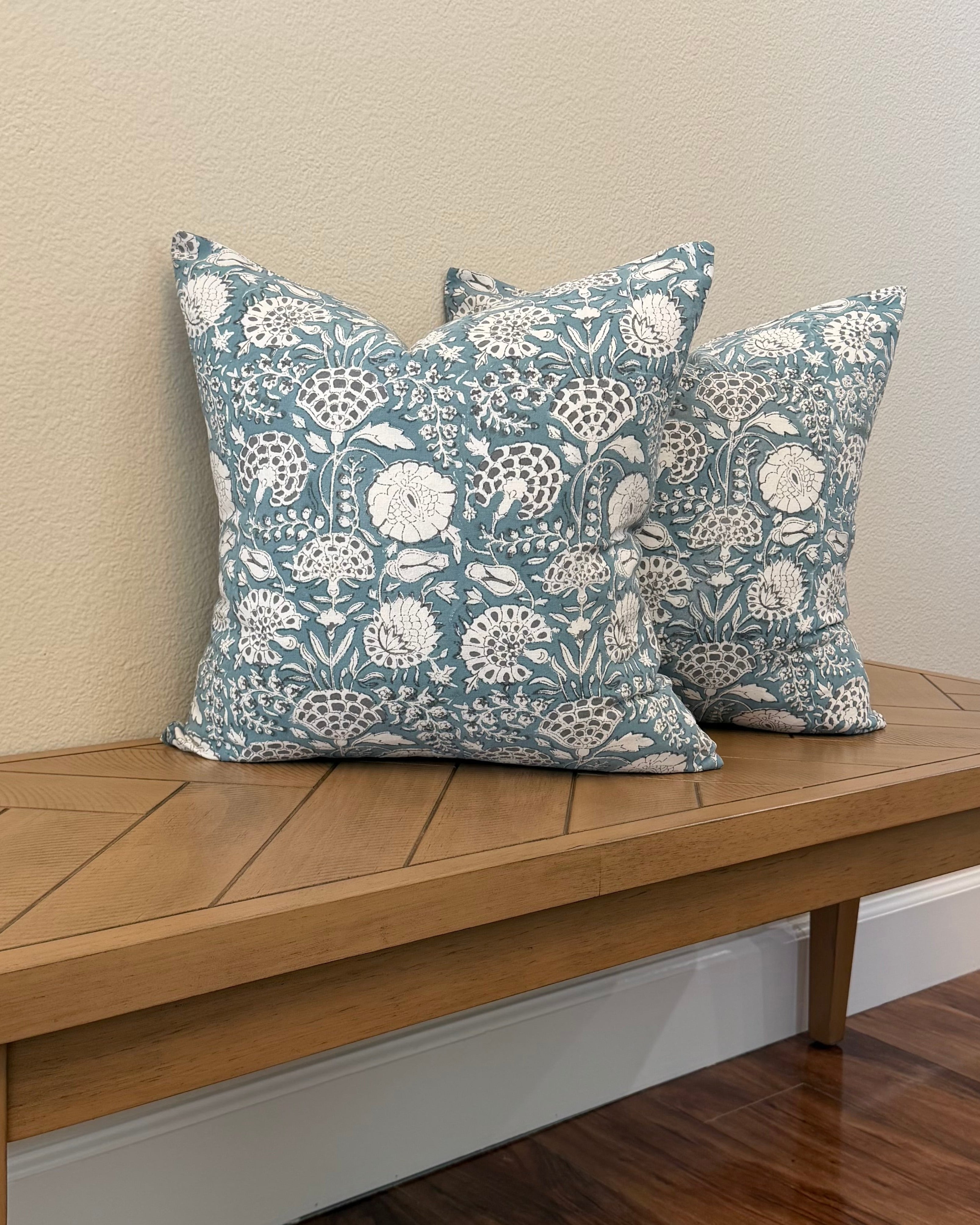 Hand Block printed throw pillow with floral vine motifs in muted bluish gray and white.