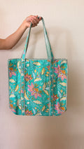 Hand-block printed quilted cotton tote bag. Featuring turquoise backdrop, playful pink florals, golden leaves, and winding botanical details.